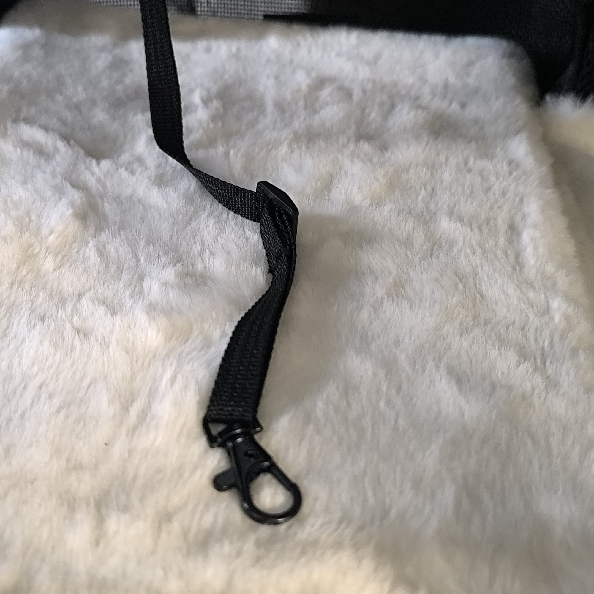 Verstelbaar veiligheidslijntje met stevige metalen karabiner op het zachte witte matje