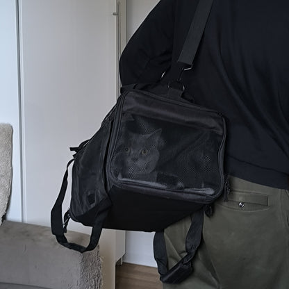 Tas met kat aan de schouderband gedragen, kat zichtbaar achter het gaas